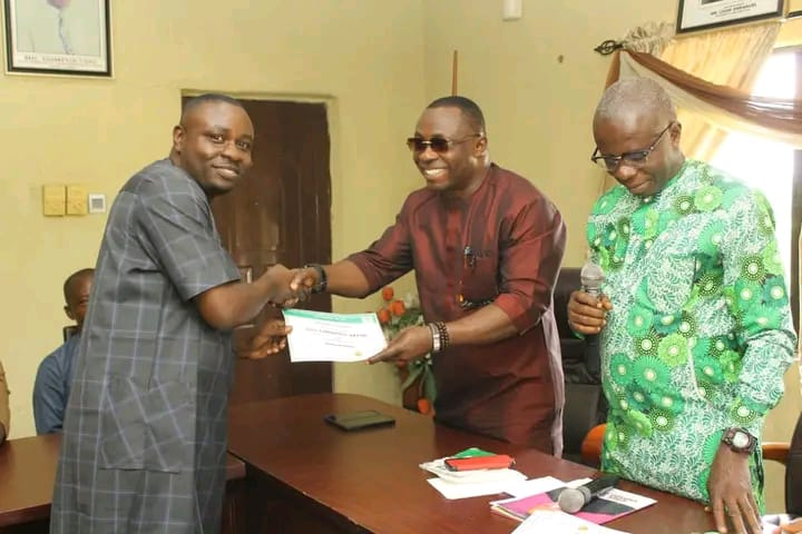 Re-elected chairman of SWAN in Akwa Ibom State, Comrade Emmanuel Akpan (left), receiving his certificate from the South-south Vice President, Otuekong Bonny Nyong (middle) and Electoral board chairman, Justice Udousoro (Photo Credit: Jimoh Otisoro)