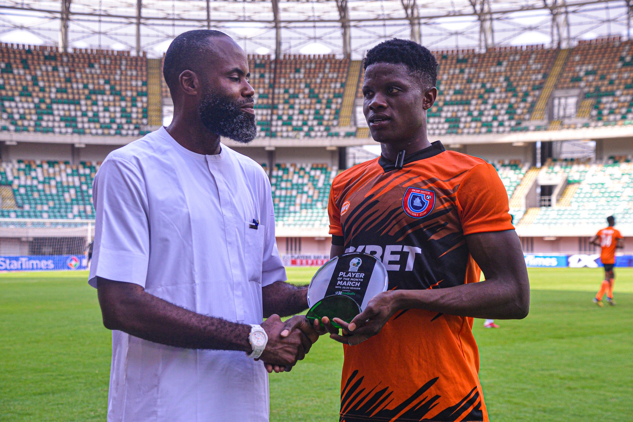 Akwa Ibom State FA Chairman, Mr Samuel Umoh presenting an award to Akwa United FC forward Sani Suleiman before a recent NPFL game.